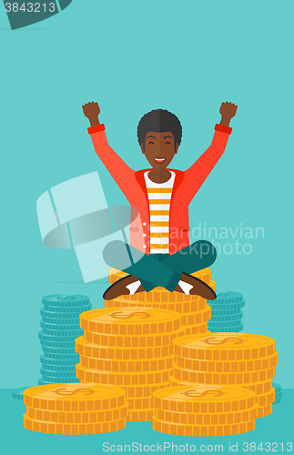 Image of  Happy businessman sitting on coins.