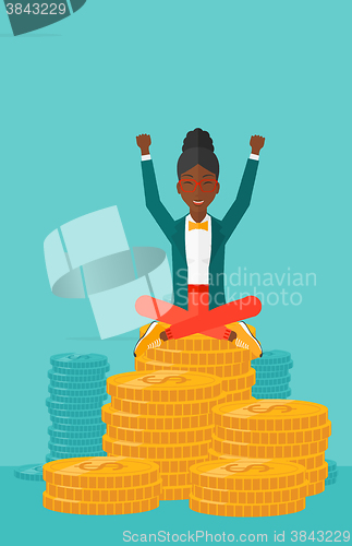 Image of  Happy business woman sitting on coins.