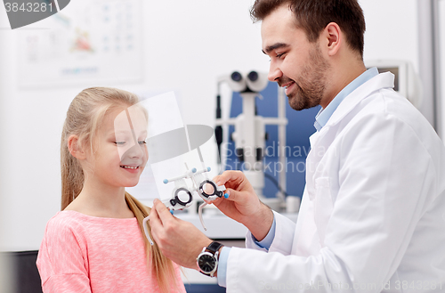 Image of optician with trial frame and girl at clinic