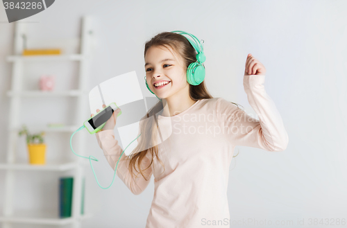 Image of girl with smartphone and headphones at home