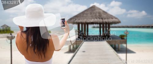Image of smiling young woman taking selfie with smartphone