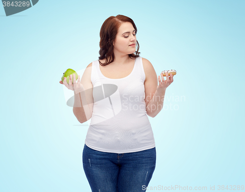 Image of young plus size woman choosing apple or cookie