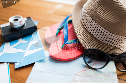 Image of close up of travel map, flip-flops, hat and camera