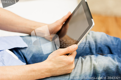 Image of close up of man working with tablet pc at home