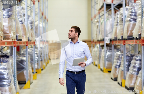 Image of businessman with tablet pc at warehouse