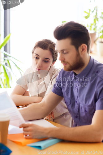 Image of creative team with reading paper in office