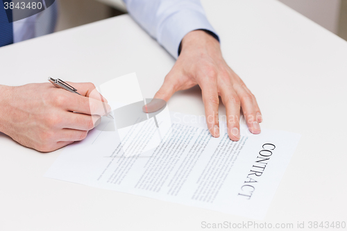 Image of close up of male hands signing contract document