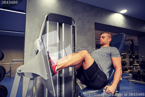Image of man flexing leg muscles on gym machine