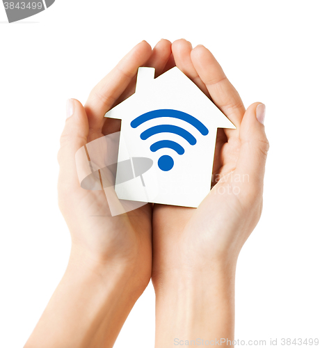 Image of hands holding house with radio wave signal icon