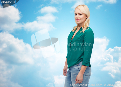 Image of smiling young woman in shirt and jeans