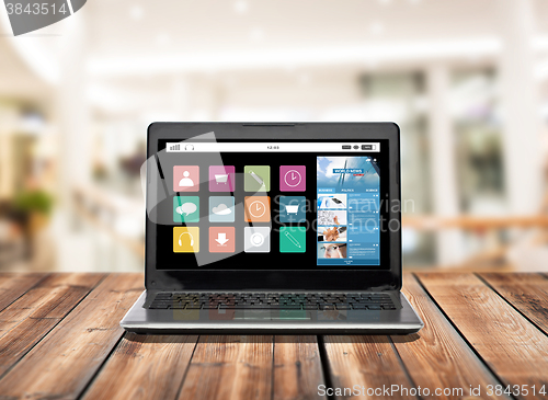 Image of laptop computer with application icons on screen