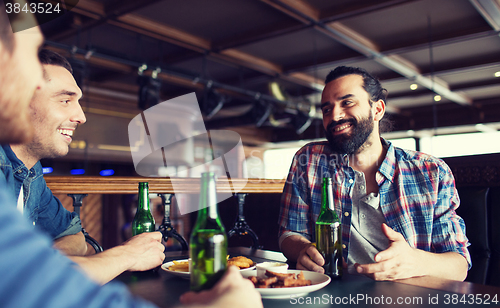 Image of happy male friends drinking beer at bar or pub