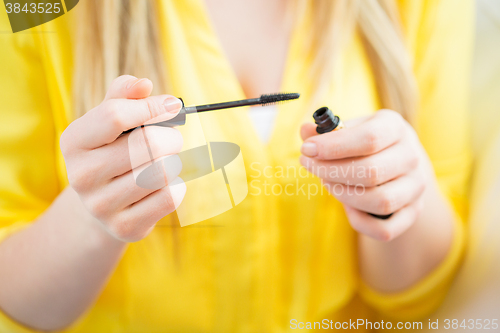 Image of close up of woman with mascara applying makeup