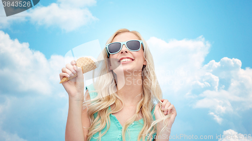 Image of happy young woman in sunglasses eating ice cream