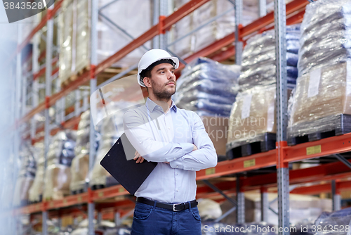 Image of happy businessman with clipboard at warehouse