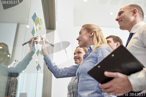 Image of smiling business people with marker and stickers