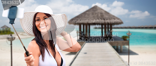 Image of smiling young woman taking selfie with smartphone