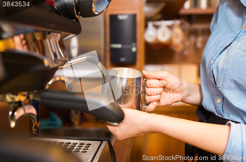 Image of close up of woman making coffee by machine at cafe