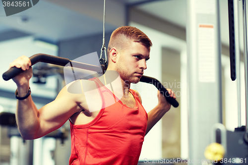 Image of man flexing muscles on cable machine gym