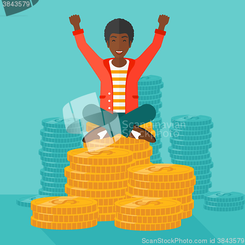 Image of  Happy businessman sitting on coins.