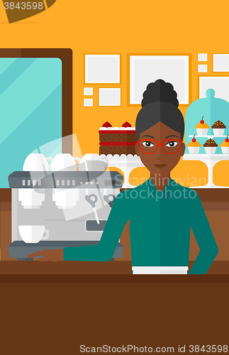 Image of Barista standing near coffee maker.