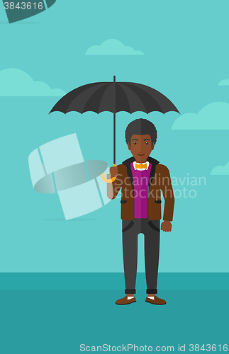 Image of Businessman standing with umbrella.