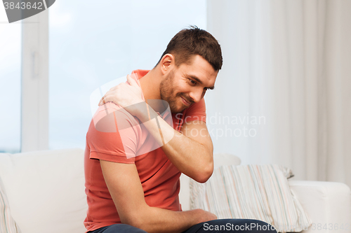 Image of unhappy man suffering from neck pain at home