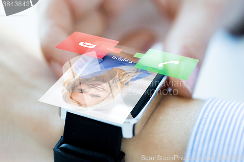 Image of close up of hand with incoming call on smart watch