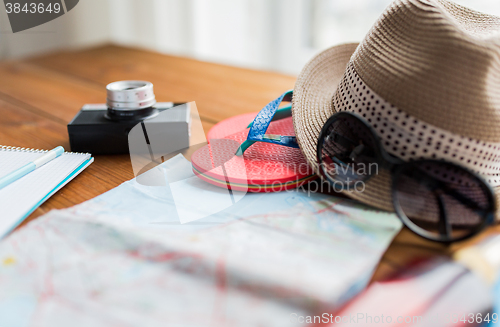 Image of close up of travel map, flip-flops, hat and camera