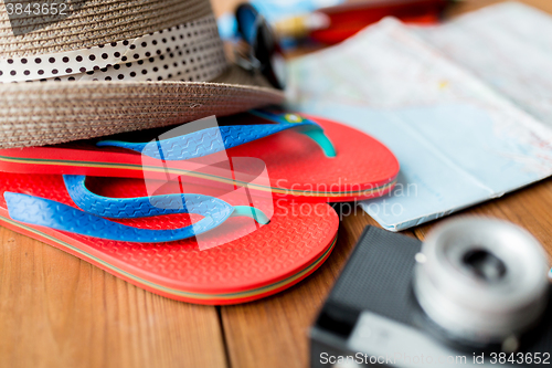 Image of close up of travel map, flip-flops, hat and camera