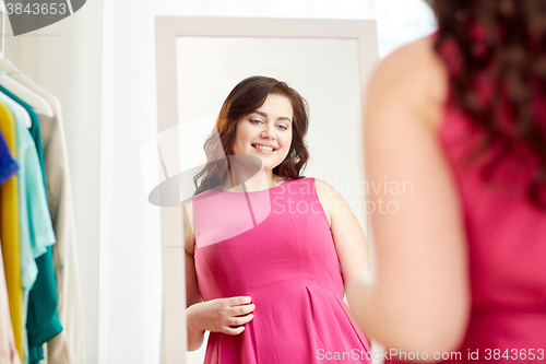 Image of happy plus size woman posing at home mirror