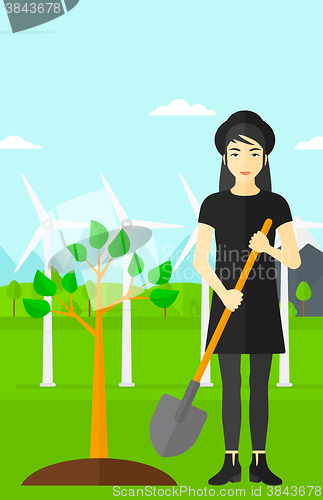 Image of Woman plants tree.