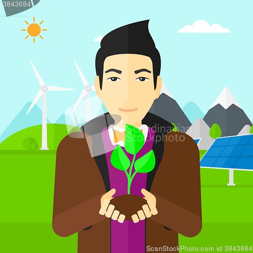 Image of Man holding plant.