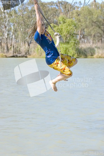 Image of girl swinging over river