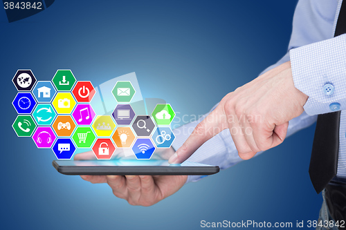 Image of Businessman holding a tablet pc with mobile applications icons on virtual screen . Internet and business concept.