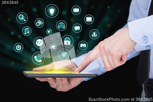 Image of Businessman holding a tablet pc with mobile applications icons on virtual screen . Internet and business concept.