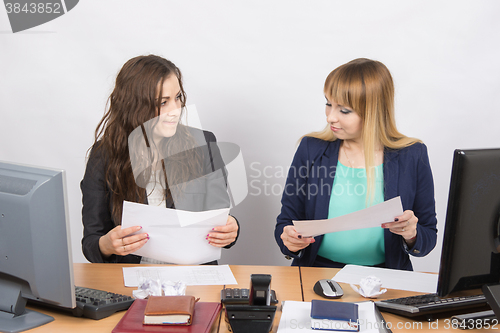 Image of Office colleagues girl at a desk browsing documents