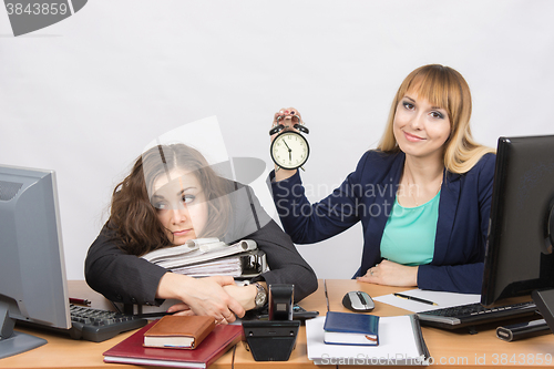 Image of Two girls in the office at the end of the day, one positive, the other exhausted