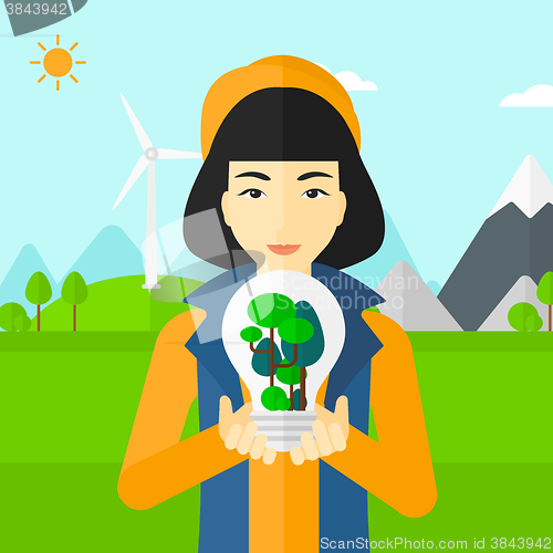 Image of Woman with lightbulb and trees inside.