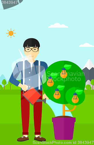 Image of Man watering tree with light bulbs.