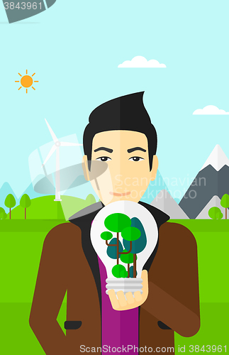 Image of Man with lightbulb and trees inside.