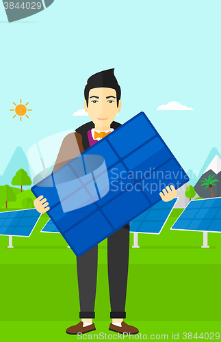 Image of Man holding solar panel.