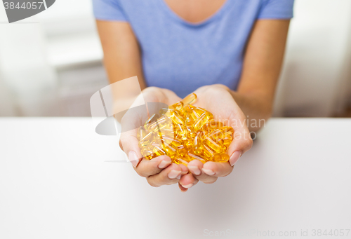 Image of close up of woman hands holding pills or capsules