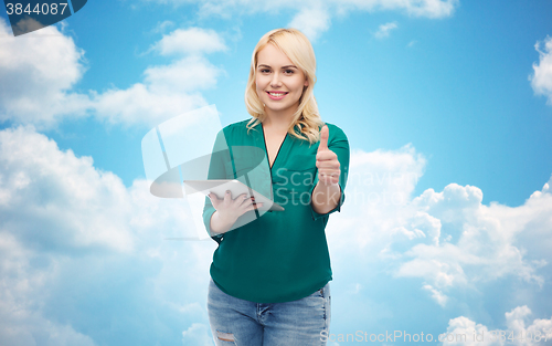 Image of smiling woman with tablet pc showing thumbs up