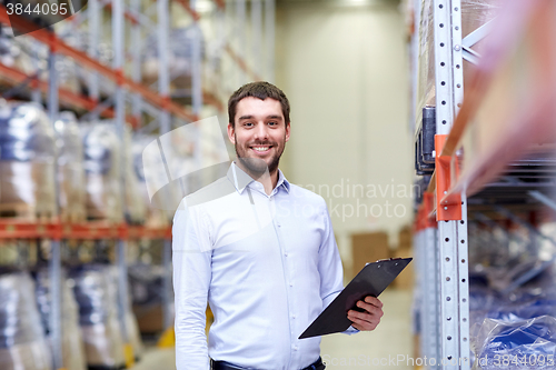 Image of happy businessman with clipboard at warehouse