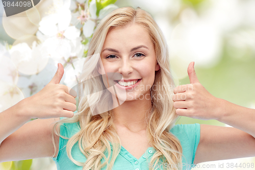 Image of happy woman or teenage girl showing thumbs up