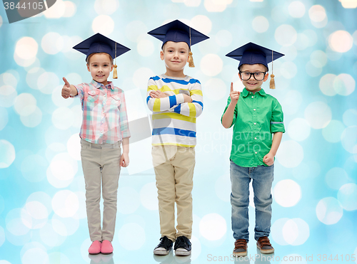 Image of happy children in bachelor hats and eyeglasses