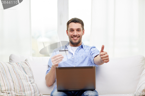 Image of man with laptop and credit card showing thumbs up