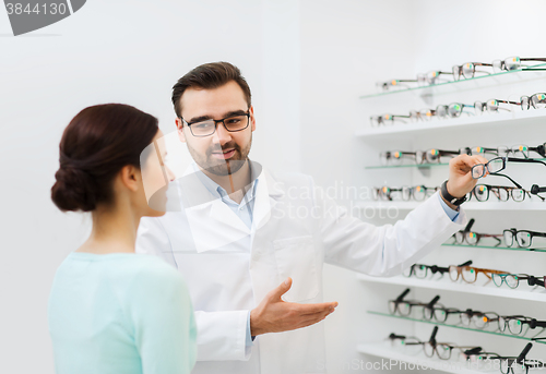 Image of woman and optician showing glasses at optics store