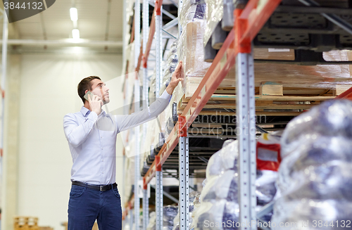 Image of serious man calling on smartphone at warehouse